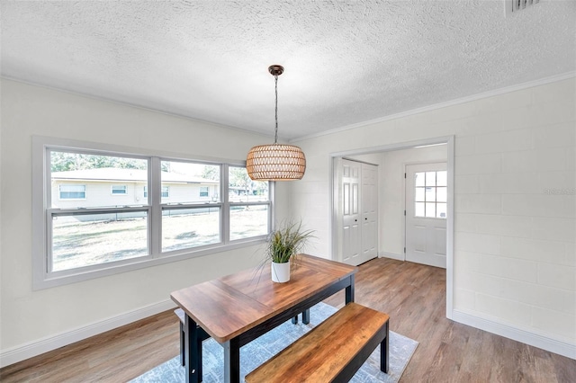 dining space featuring light hardwood / wood-style flooring and a textured ceiling