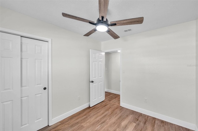 unfurnished bedroom featuring a closet, ceiling fan, and light wood-type flooring