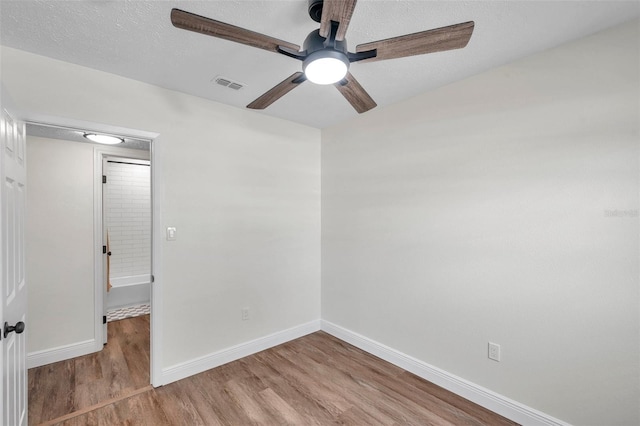 unfurnished room featuring ceiling fan, a textured ceiling, and light hardwood / wood-style floors