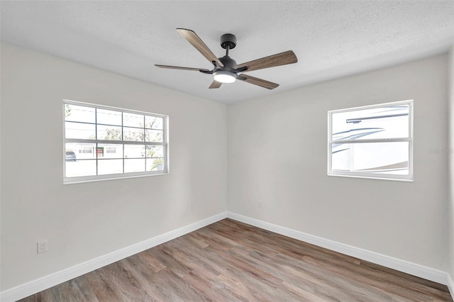 unfurnished room featuring ceiling fan, hardwood / wood-style flooring, and a textured ceiling