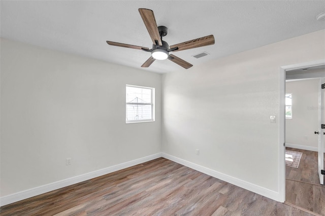 spare room with hardwood / wood-style flooring and ceiling fan