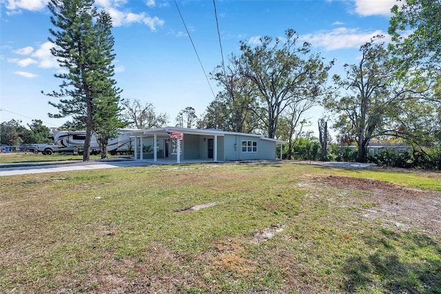 view of front of home with a carport and a front lawn