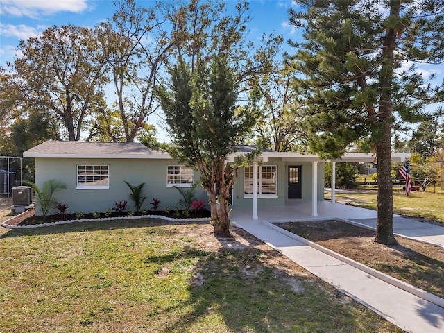 view of front of house with a carport, central AC unit, and a front yard