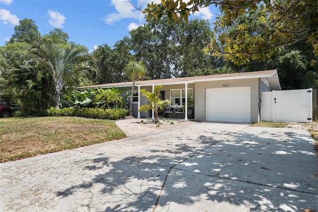 ranch-style home with a garage and a front lawn