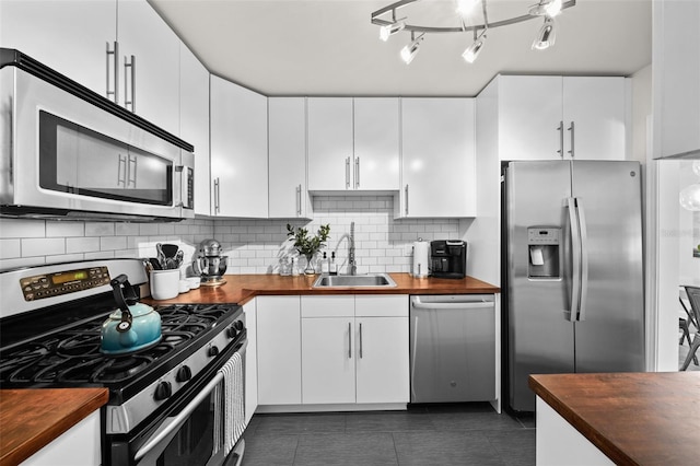 kitchen featuring white cabinetry, sink, wooden counters, and appliances with stainless steel finishes