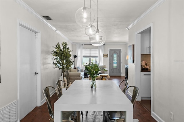 dining area with ornamental molding and dark hardwood / wood-style flooring