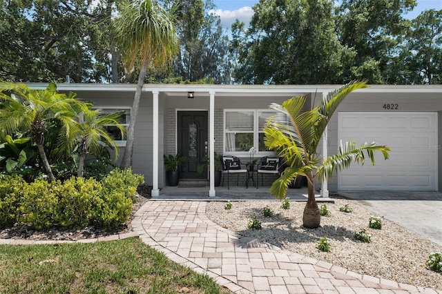 doorway to property featuring a garage and covered porch