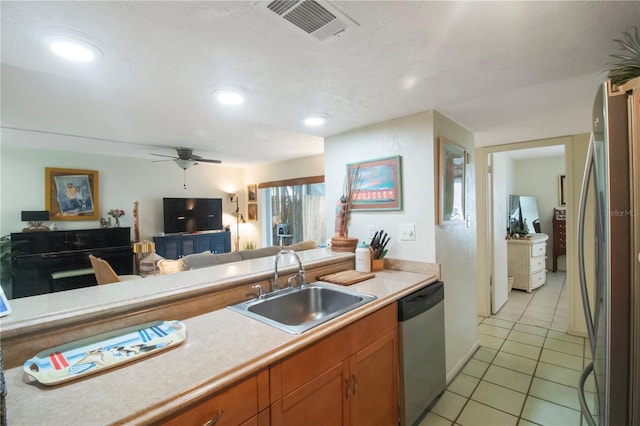 kitchen with sink, light tile patterned floors, ceiling fan, appliances with stainless steel finishes, and a textured ceiling