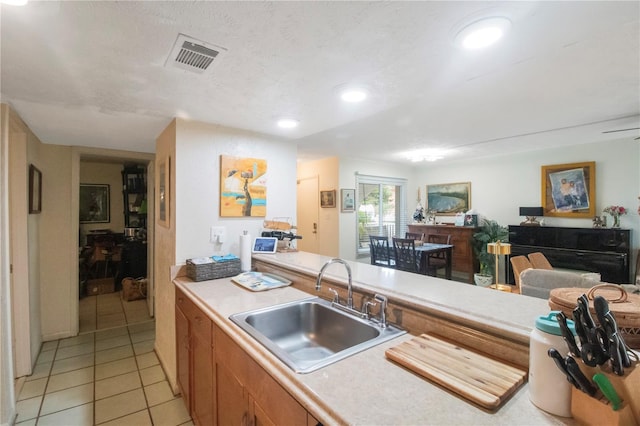 kitchen with sink, light tile patterned floors, and a textured ceiling