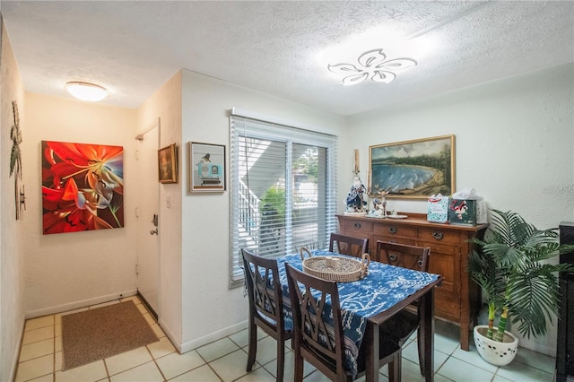 dining space featuring a textured ceiling and light tile patterned floors