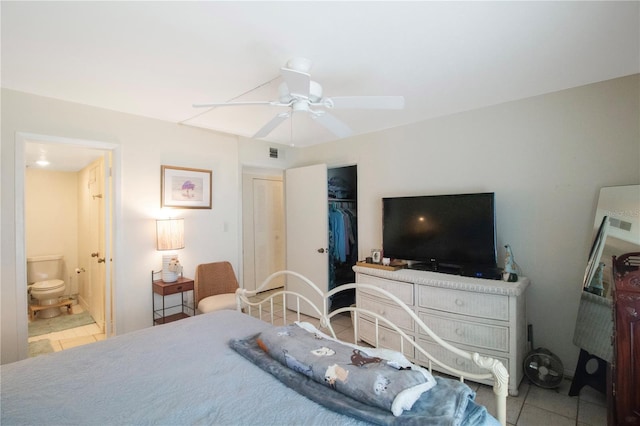 bedroom with connected bathroom, tile patterned floors, ceiling fan, and a closet