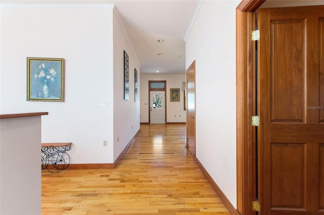 hallway featuring crown molding and light wood-type flooring