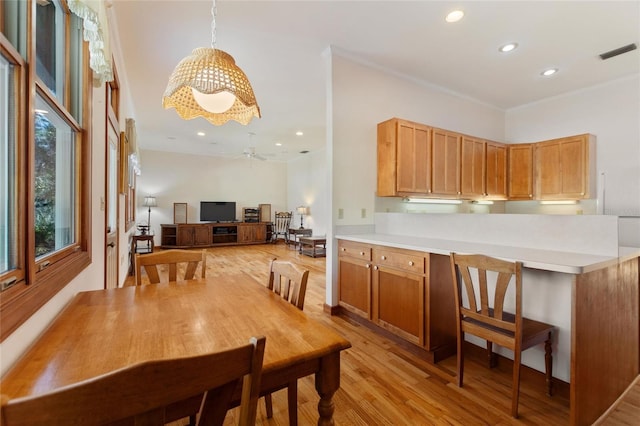 dining space featuring ceiling fan, crown molding, and light hardwood / wood-style floors