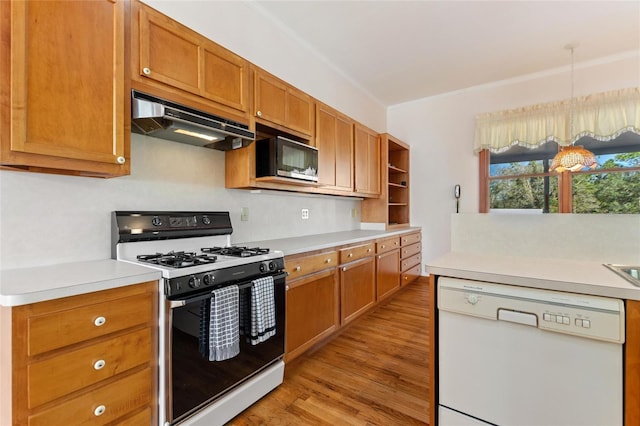 kitchen featuring crown molding, light wood-type flooring, white dishwasher, range with gas stovetop, and pendant lighting