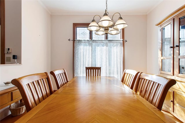 dining area with crown molding and a chandelier