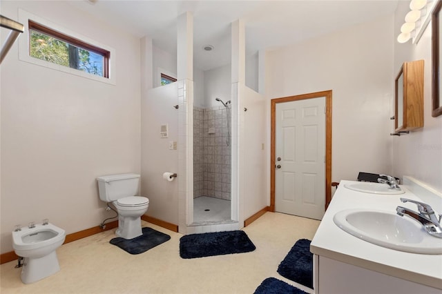 bathroom with a bidet, vanity, toilet, and a tile shower