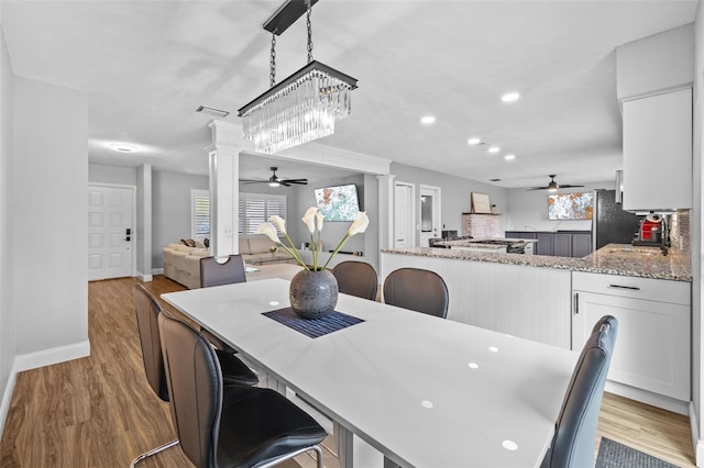 dining space with ceiling fan, a healthy amount of sunlight, and light wood-type flooring