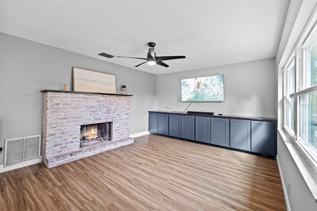 unfurnished living room with a fireplace, light hardwood / wood-style flooring, and ceiling fan