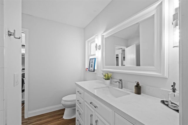 bathroom featuring wood-type flooring, vanity, and toilet