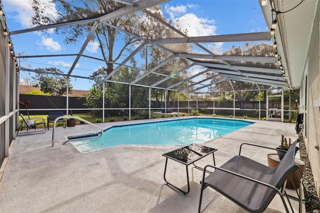 view of swimming pool featuring a patio and glass enclosure