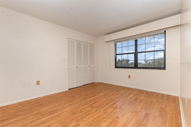 unfurnished bedroom featuring a closet and light hardwood / wood-style flooring