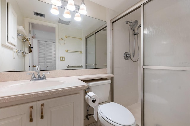 bathroom with vanity, a shower with shower door, and toilet