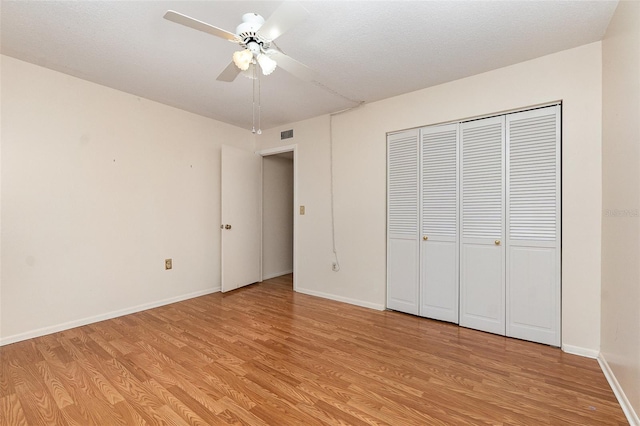 unfurnished bedroom featuring ceiling fan, a closet, and light hardwood / wood-style flooring