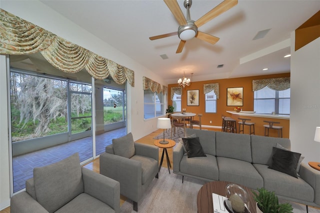 living room featuring ceiling fan with notable chandelier