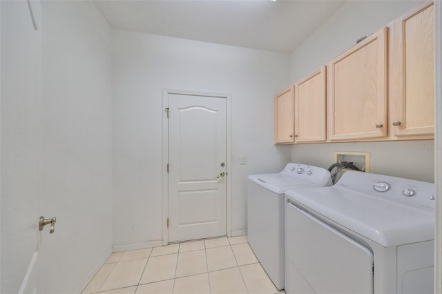 washroom with cabinets, washer and dryer, and light tile patterned floors