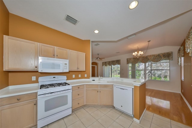 kitchen with white appliances, light brown cabinetry, kitchen peninsula, and sink