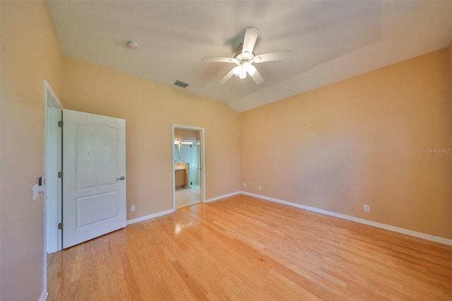 unfurnished bedroom featuring ensuite bathroom, lofted ceiling, ceiling fan, and light wood-type flooring