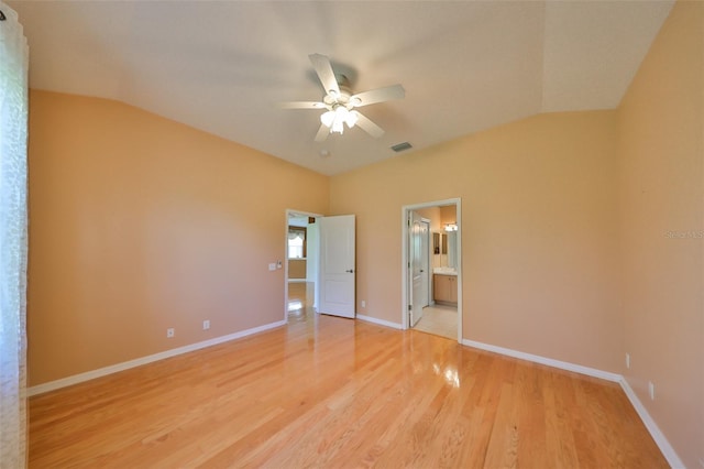 unfurnished bedroom featuring vaulted ceiling, ensuite bath, ceiling fan, and light hardwood / wood-style floors