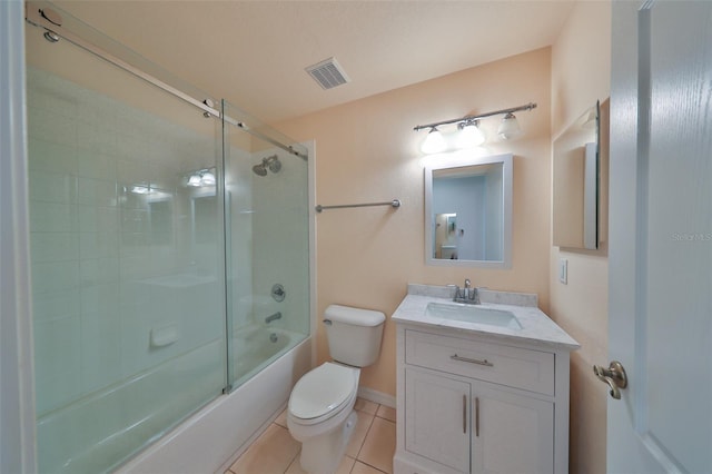 full bathroom featuring vanity, tile patterned floors, shower / bath combination with glass door, and toilet