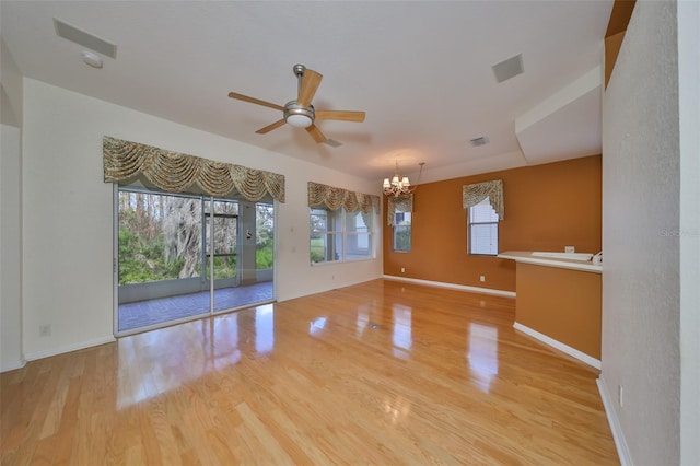 unfurnished room featuring ceiling fan with notable chandelier and light hardwood / wood-style floors