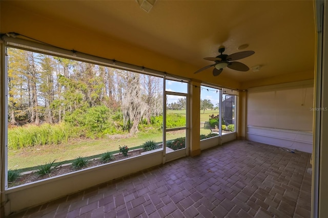 unfurnished sunroom featuring ceiling fan