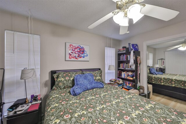 bedroom featuring ceiling fan, a textured ceiling, and wood finished floors