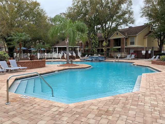 pool featuring fence and a patio