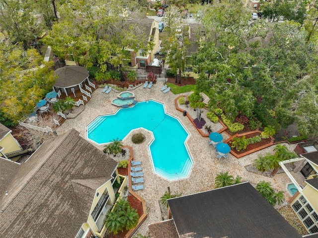 pool with a patio area and a hot tub