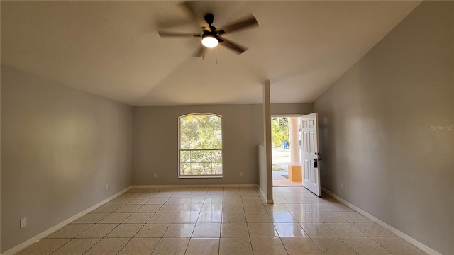 tiled empty room featuring vaulted ceiling and ceiling fan