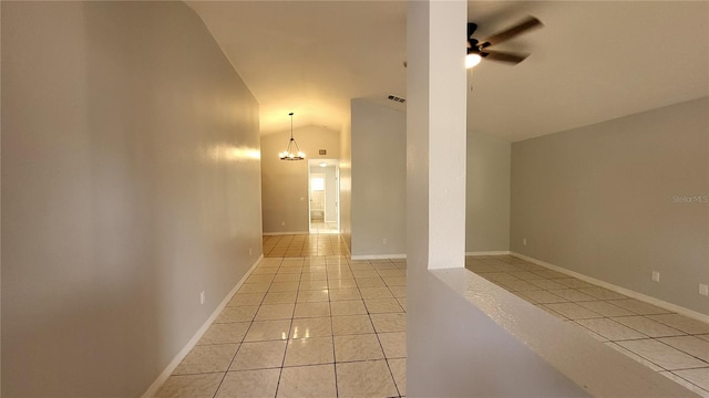 hallway with light tile patterned flooring, high vaulted ceiling, and an inviting chandelier