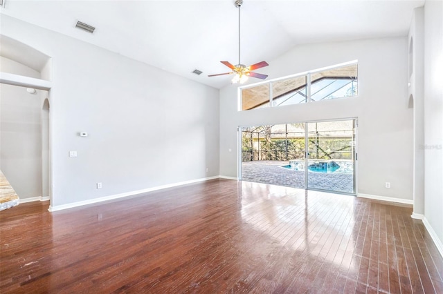 unfurnished living room featuring dark wood-type flooring, ceiling fan, and high vaulted ceiling