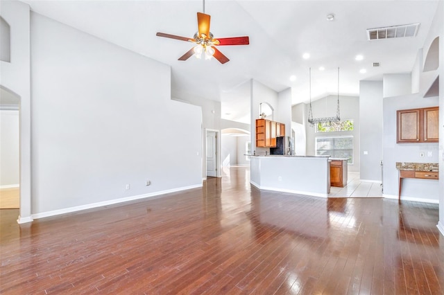 unfurnished living room featuring ceiling fan, hardwood / wood-style floors, and high vaulted ceiling