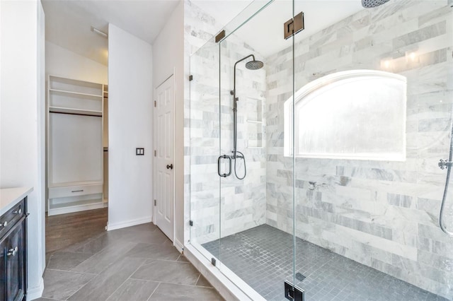 bathroom with a shower with door and vanity