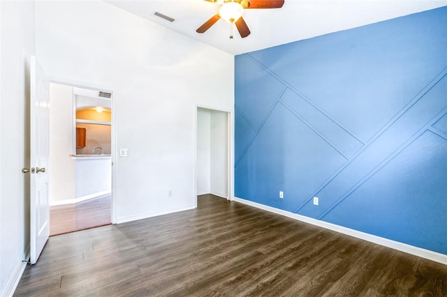 spare room featuring dark wood-type flooring and ceiling fan