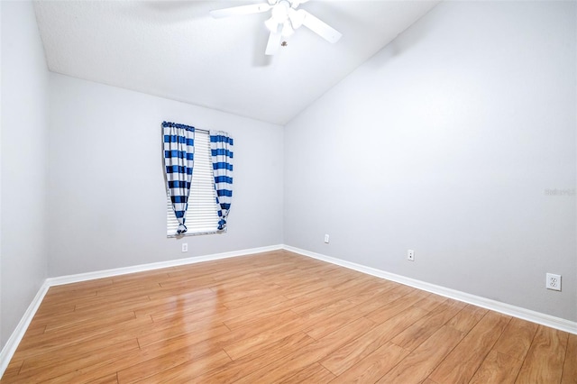 empty room with hardwood / wood-style flooring, ceiling fan, and lofted ceiling