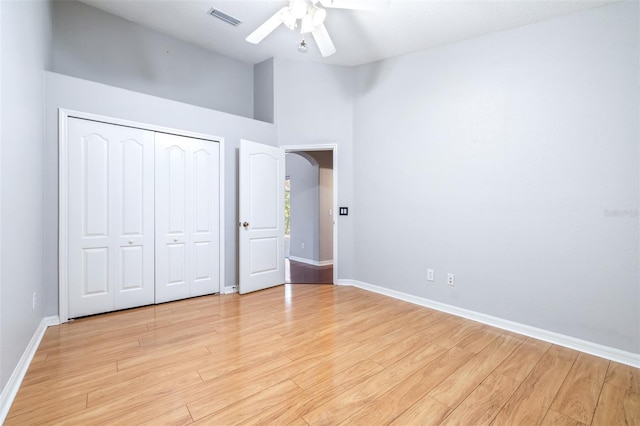 unfurnished bedroom with vaulted ceiling, ceiling fan, light hardwood / wood-style floors, and a closet