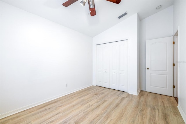 unfurnished bedroom featuring ceiling fan, lofted ceiling, light wood-type flooring, and a closet