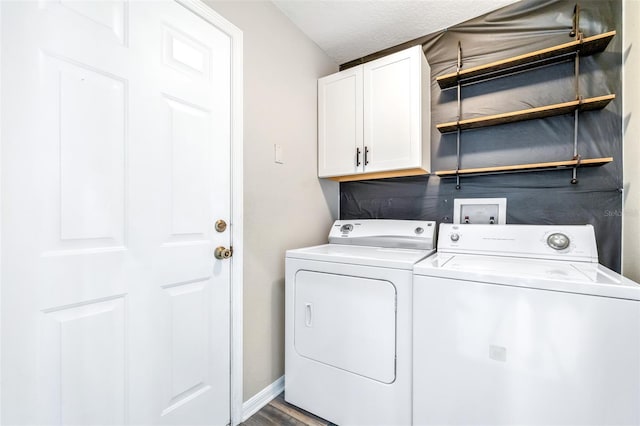 laundry area featuring hardwood / wood-style flooring, washer and clothes dryer, cabinets, and a textured ceiling