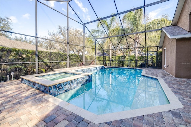 view of pool featuring an in ground hot tub, a patio area, and glass enclosure