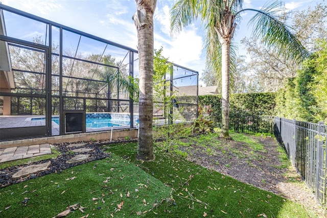 view of yard featuring a fenced in pool and glass enclosure